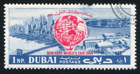 DUBAI - CIRCA 1964: stamp printed by Dubai, shows New York and Emblem of Fair, circa 1964のeditorial素材