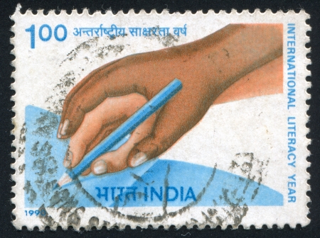 INDIA - CIRCA 1990: stamp printed by India, shows hands, pencil, circa 1990のeditorial素材
