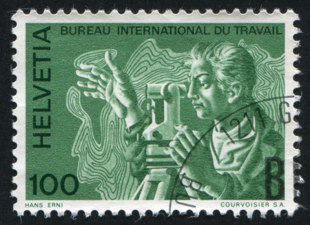 SWITZERLAND - CIRCA 1983: stamp printed by Switzerland, shows Surveyor with theodolite and topographical map, circa 1983のeditorial素材