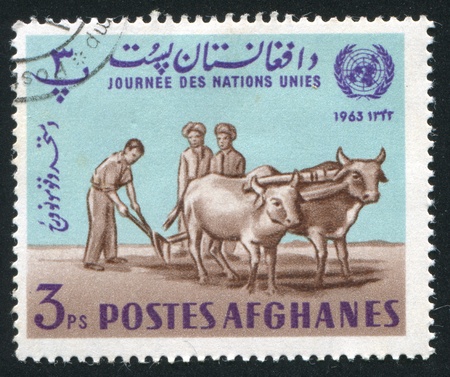 AFGHANISTAN - CIRCA 1964: stamp printed by Afghanistan, shows Plowman, circa 1964のeditorial素材