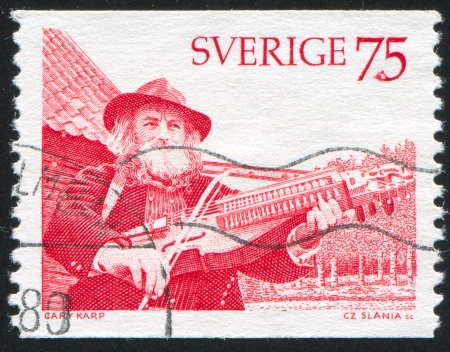 SWEDEN - CIRCA 1975: stamp printed by Sweden, shows Old Man Playing Key Fiddle, circa 1975のeditorial素材