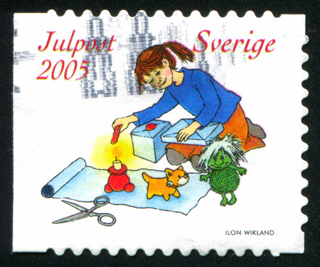 SWEDEN - CIRCA 2005: stamp printed by Sweden, shows Girl wrapping gifts, circa 2005のeditorial素材