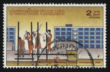 RUSSIA KALININGRAD, 2 JUNE 2016: stamp printed by Thailand, shows workers building a house, circa 1988のeditorial素材