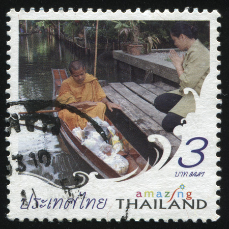 RUSSIA KALININGRAD, 4 JUNE 2016: stamp printed by Thailand, shows monk in a boat and a beadswoman, circa 2007のeditorial素材