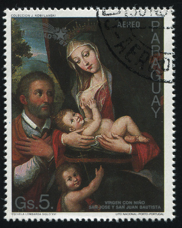 RUSSIA KALININGRAD, 15 APRIL 2017: stamp printed by Paraguay, shows Painting Virgin and Child with St Joseph and St John the Baptist by Escuela Lombarda Siglo, circa 1987のeditorial素材