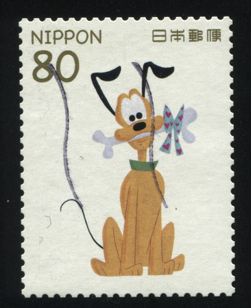 RUSSIA KALININGRAD, 22 APRIL 2016: stamp printed by Japan, shows dog Pluto with bone, circa 2011のeditorial素材