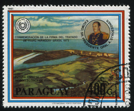 RUSSIA KALININGRAD, 19 APRIL 2017: stamp printed by Paraguay, shows Itaipu hydroelectric dam and the portrait of Alfredo Stroessner, circa 1981のeditorial素材
