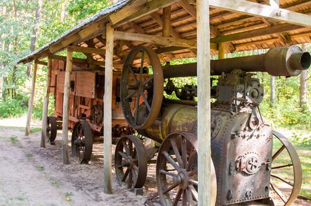 Vintage steam engine for agriculture. Warm bright summer day.