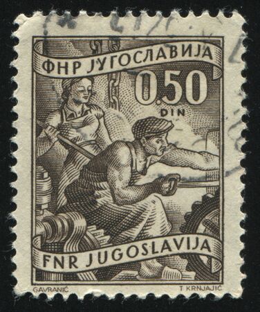 RUSSIA KALININGRAD, 12 NOVEMBER 2016: stamp printed by Yugoslavia, shows two workers of metallurgy, circa 1950のeditorial素材