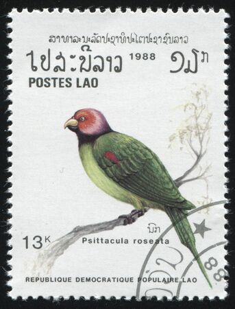 RUSSIA KALININGRAD, 26 MARCH 2019: stamp printed by Laos shows bird on a branch, circa 1988のeditorial素材