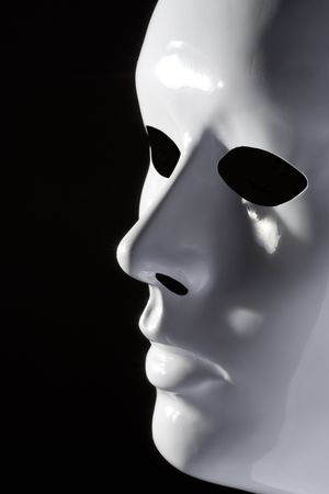 Suggestive simple white mask on black backgroundの写真素材