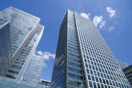 Glass skyscrapers on blue sky reflecting skyの写真素材