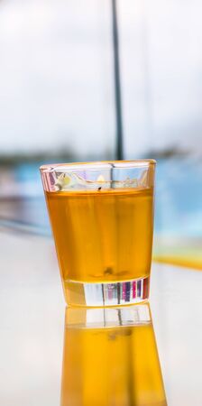 Yellow candle in a glass  with reflection.の写真素材