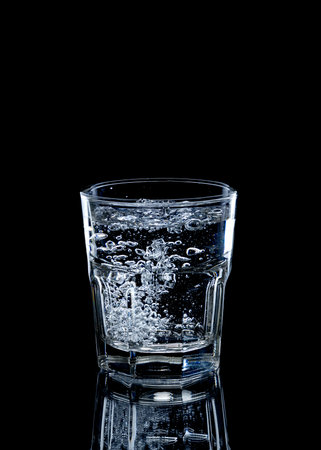 A glass of water on black background.の写真素材