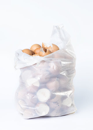 Broken egg shells in a plastic bag on a white background.の写真素材