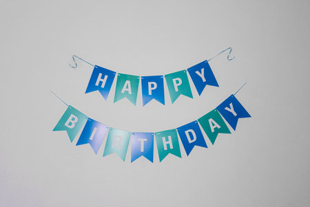 Happy Birthday triangle flag garlands decorate on wall background.の写真素材