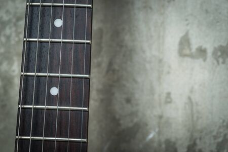 Electric guitar near the concrete wallの写真素材