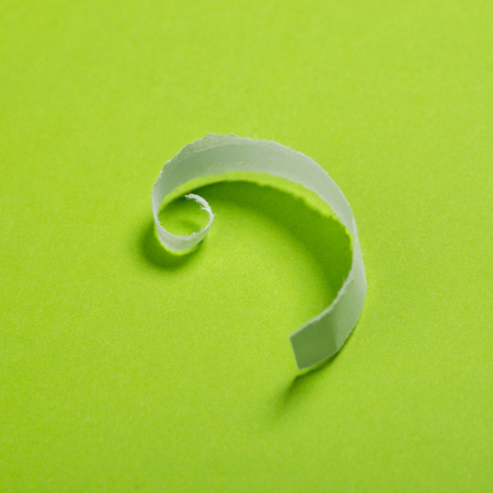 Piece of white torn paper over the green background