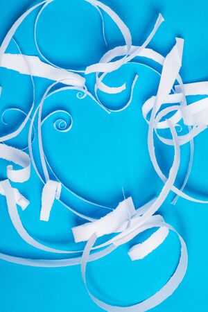 Pieces of white torn paper over the blue background