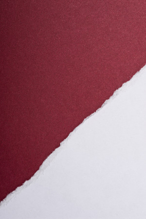 Piece of white torn paper over the dark red backgroundの写真素材