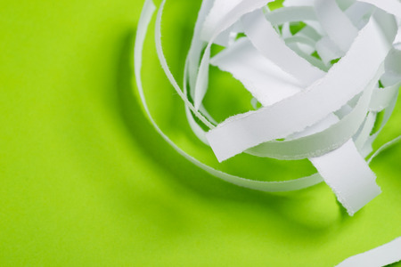 Pieces of white torn paper over the green backgroundの写真素材