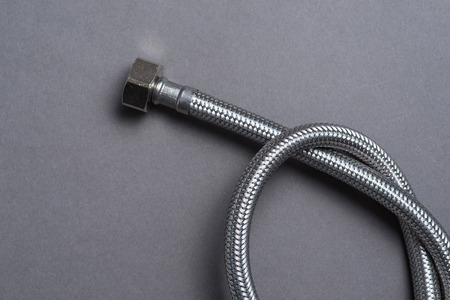 New braided stainless steel water hose over grey backgroundの写真素材