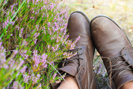 A pair of heavy worn brown leather shoes over the countryside backgroundの写真素材
