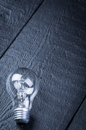 Tungsten bulb on a black wooden tableの写真素材