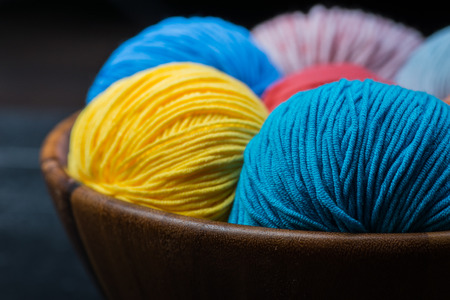Colorful knitting yarn balls in basketの写真素材
