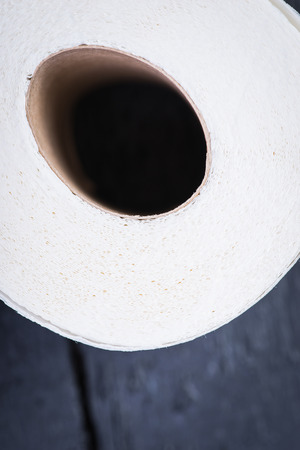 Toilet paper roll on the black wooden tableの写真素材