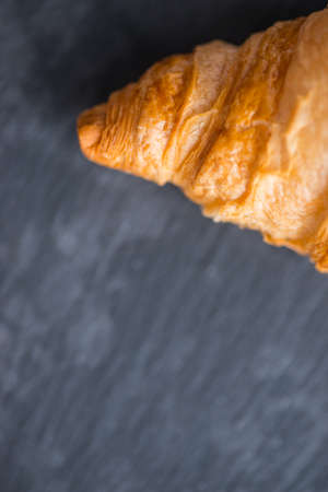 Tasty and crusty french croissant on a black stone plate in a dayligtの写真素材