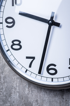 Dramatic picture of round wall clock hanging on the grey concrete wallの写真素材
