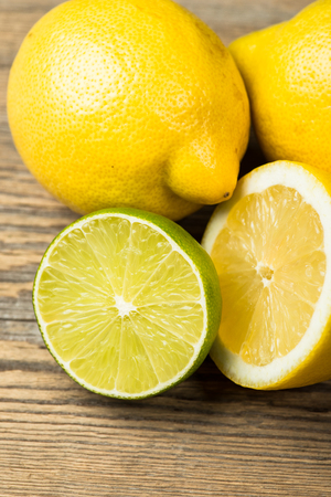 Fresh and juicy lemons and lime on a wooden tableの写真素材