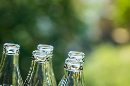 Glass bottles over the green sunny backgroundの写真素材