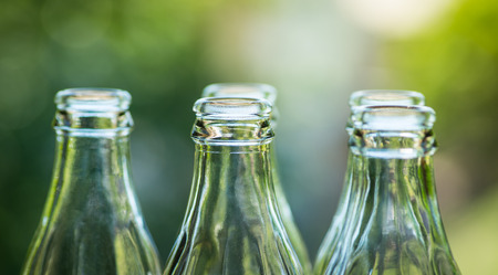 Glass bottles over the green sunny backgroundの写真素材