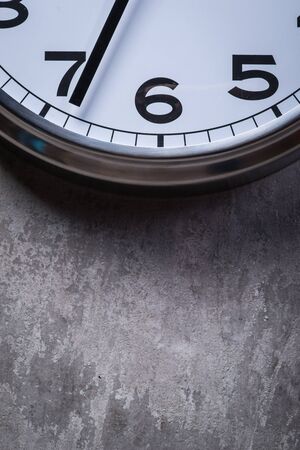 Dramatic picture of round wall clock hanging on the grey concrete wallの写真素材