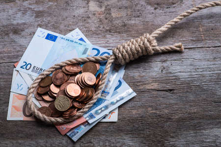 Hangman's noose with money on brown wooden backgroundの写真素材