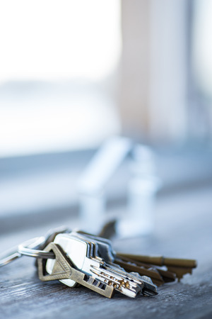 A bunch of vintage keys with metal house on the wooden table