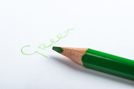Green pencil on a white paperの写真素材