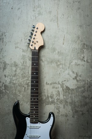 Electric guitar near the concrete wallの写真素材