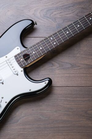 Electric guitar with mediator on a brown wooden floorの写真素材