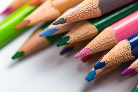 Several color pencils on a white paper sheetの写真素材