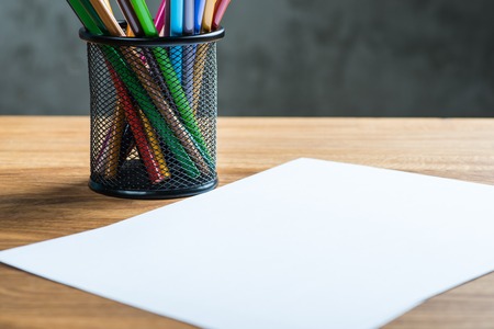 Bunch of color pencils with a white paper sheetの写真素材