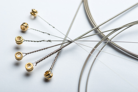 Electric guitar strings on white surfaceの写真素材