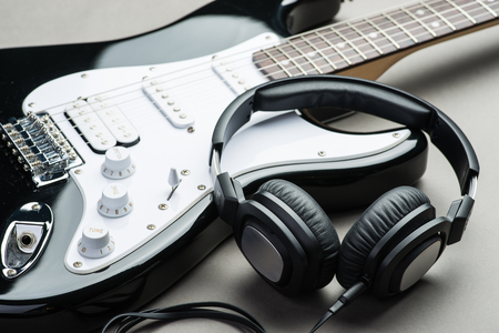 Electric guitar with headphones on a brown wooden floorの写真素材