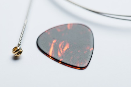 Electric guitar string with mediator on white surfaceの写真素材