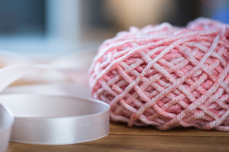Ball of pink knitting yarn with ribbonの写真素材