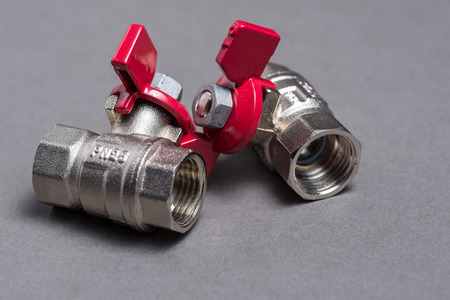 Water valves with red handle on grey background