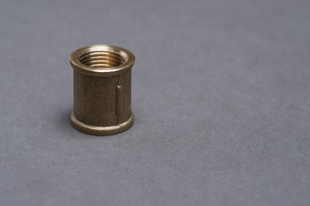 Brass plumbing fitting on grey surfaceの写真素材