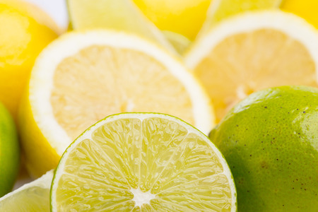 Whole and sliced fresh limes and lemons on over white background, DOFの写真素材